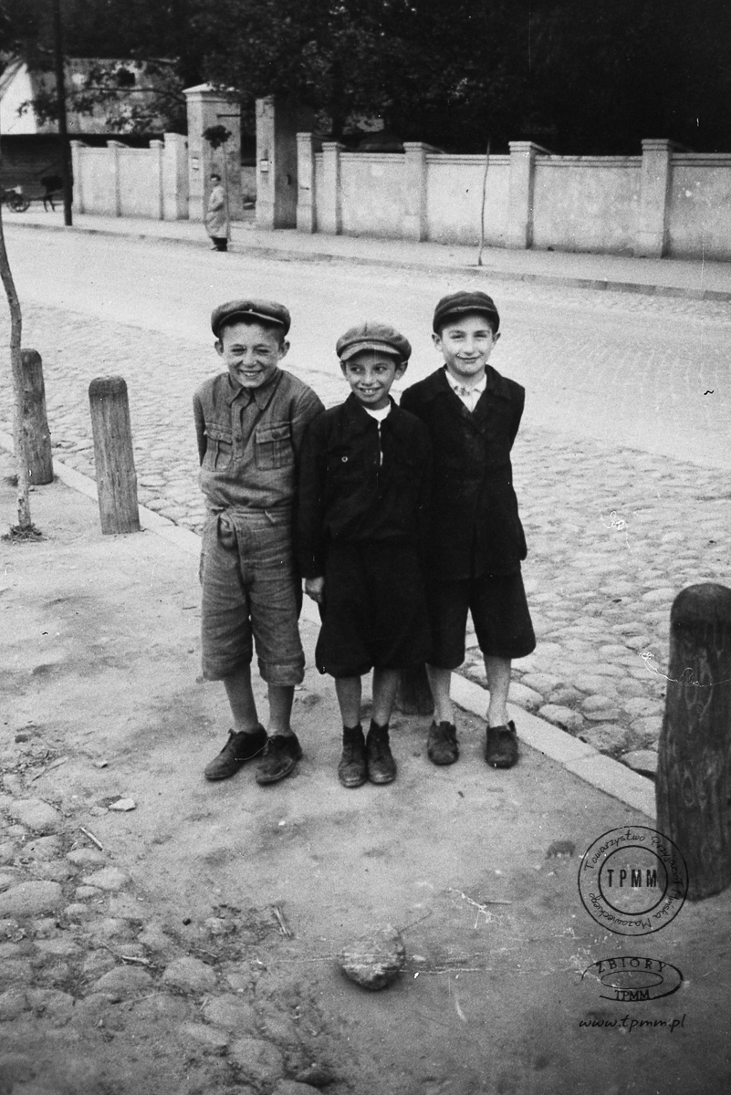 Żydowskie dzieci stojące przy ul. Warszawskiej. W tle mur kościoła.